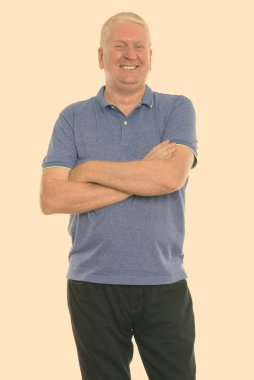 Studio shot of mature man isolated against yellow background