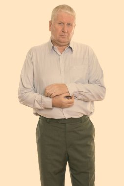 Studio shot of mature man isolated against yellow background