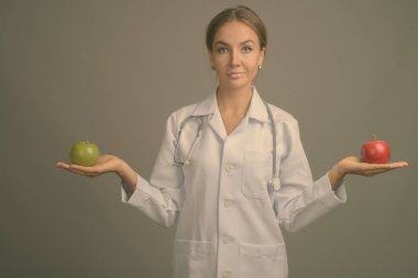 Gri arka planda genç ve güzel bir kadının stüdyo çekimi.