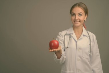 Gri arka planda genç ve güzel bir kadının stüdyo çekimi.