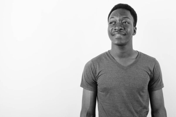 Studio shot of young handsome African man against white background in black and white