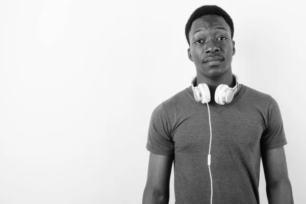 Joven hombre africano guapo con auriculares sobre fondo blanco —  Fotos de Stock