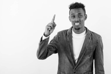 Beyaz arka planda kot ceket giyen genç sakallı Afrikalı adam.