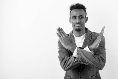 Beyaz arka planda kot ceket giyen genç sakallı Afrikalı adam.