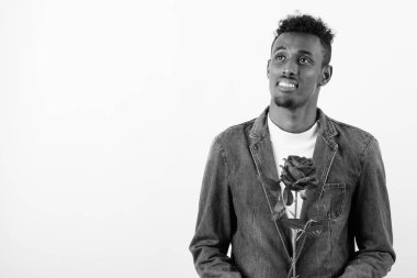 Beyaz arka planda kot ceket giyen genç sakallı Afrikalı adam.