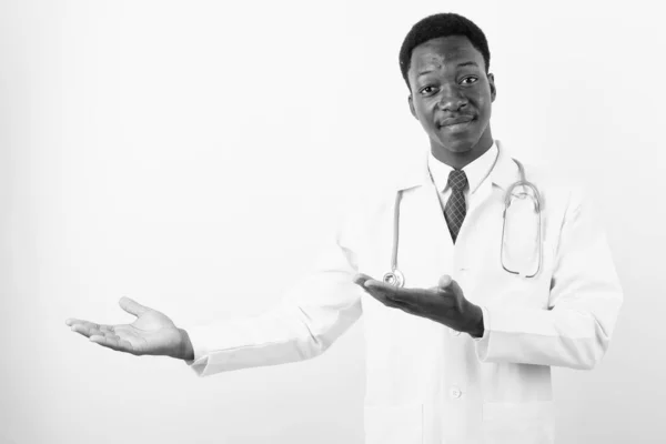 Young handsome African man doctor against white background — Stock Photo, Image