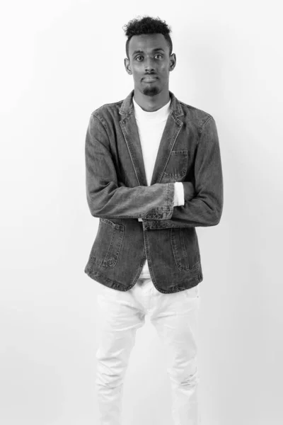 Jonge bebaarde Afrikaanse man draagt spijkerjasje tegen witte achtergrond — Stockfoto