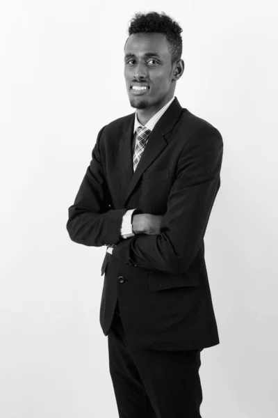 Fiatal szakállas afrikai üzletember visel öltönyt fehér háttér — Stock Fotó