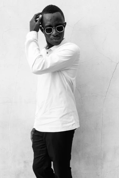 Genç, yakışıklı Afrikalı adam beton duvara yaslanmış. — Stok fotoğraf