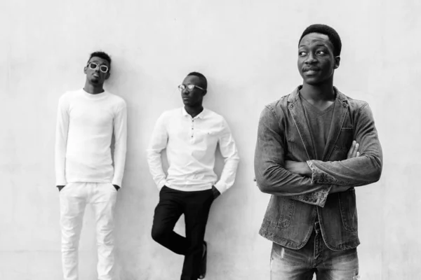 Tres jóvenes africanos colgando contra la pared de hormigón al aire libre —  Fotos de Stock