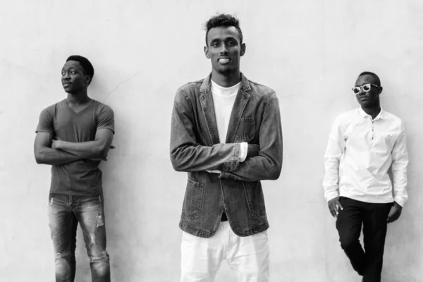 Tres jóvenes africanos colgando contra la pared de hormigón al aire libre —  Fotos de Stock