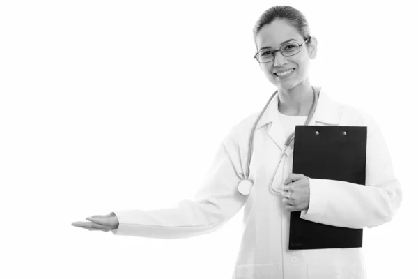 Молода щаслива жінка-лікар тримає кишеню і показує щось — стокове фото