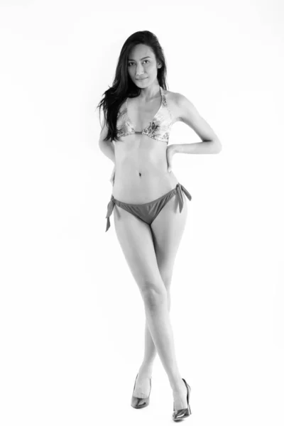 Cuerpo completo de joven hermosa mujer asiática en bikini sexy de pie y posando con los pies cruzados —  Fotos de Stock