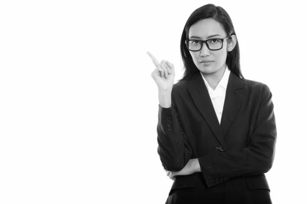 Estudio disparo de joven mujer de negocios asiática señalando el dedo hacia arriba —  Fotos de Stock