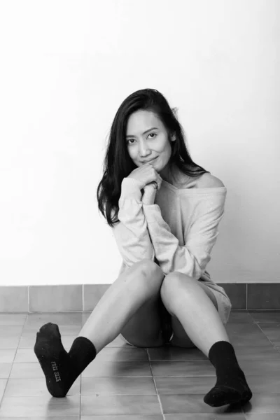 Studio plan de jeune belle femme asiatique assise sur le sol — Photo