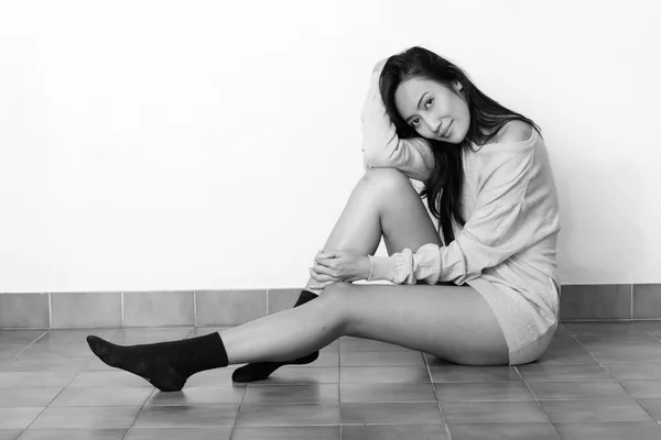 Studio shot of young beautiful Asian woman posing and sitting on the floor — Stock Photo, Image