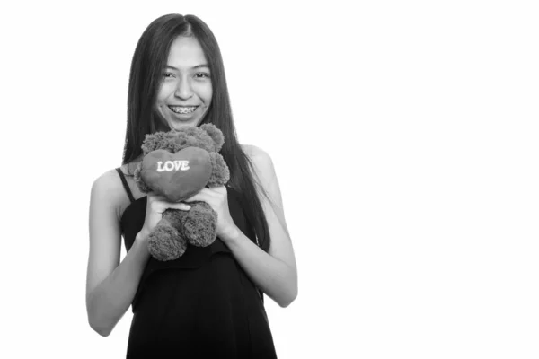 Tineri fericit asiatic adolescenta fata zâmbind în timp ce ține ursuleț cu inima și semn de dragoste — Fotografie, imagine de stoc