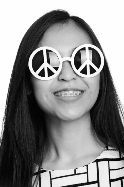 对年轻快乐亚洲少女戴着太阳镜，和平标志微笑着的脸上 — 图库照片