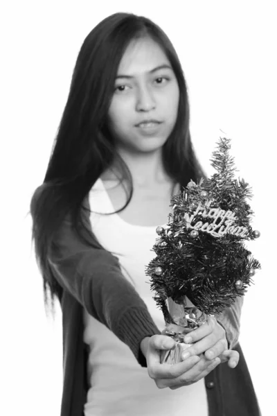 Studio shot de joven adolescente asiática dando árbol feliz año nuevo con foco en el árbol —  Fotos de Stock