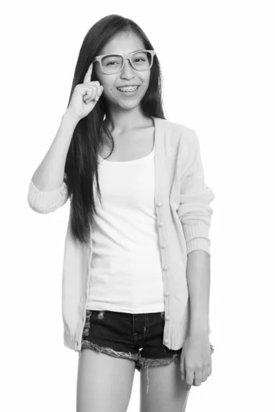 Studio colpo di giovane felice asiatico adolescente ragazza sorridente con dito sulla testa — Foto Stock