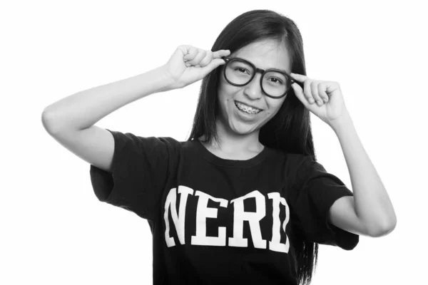 若い幸せなアジア十代オタク少女眼鏡を押しながら笑顔のスタジオ撮影 — ストック写真