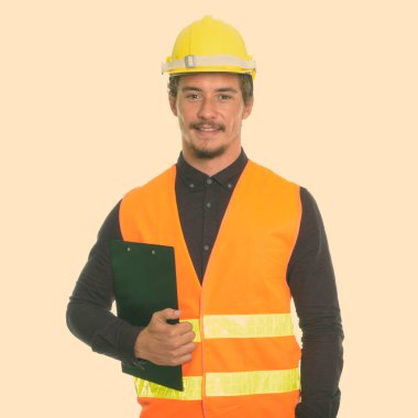 Beyaz arka plan karşı izole Pano tutarken gülümseyen genç mutlu adam inşaat işçisi Studio vurdu