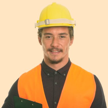 Beyaz arka plan karşı izole Pano tutarken gülümseyen genç mutlu adam inşaat işçisi kapatmak