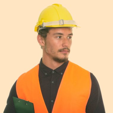 Beyaz arka plan karşı izole Pano tutarken düşünme genç yakışıklı adam inşaat işçisi kapatmak