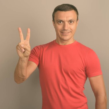 Gri arka planı kırmızı gömlek giymiş adam stüdyo çekim