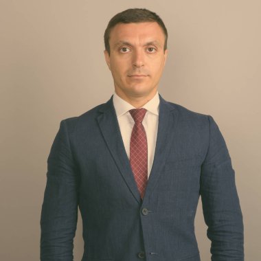 Gri arka plan karşı takım giyen işadamı stüdyo çekim