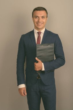 Gri arka plan karşı takım giyen işadamı stüdyo çekim