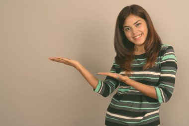 Stüdyo çekim Genç güzel Hint kadının gri bir arka plana dayanır