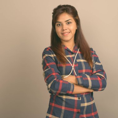 Stüdyo çekim giyen genç güzel Hintli kadın gömlek gri arka plan kontrol