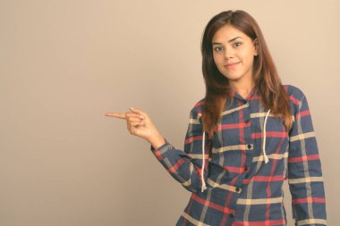 Stüdyo çekim giyen genç güzel Hintli kadın gömlek gri arka plan kontrol