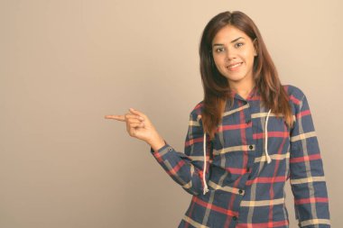 Stüdyo çekim giyen genç güzel Hintli kadın gömlek gri arka plan kontrol