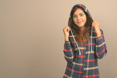 Stüdyo çekim giyen genç güzel Hintli kadın gömlek gri arka plan kontrol