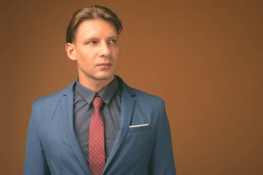 Kahverengi zemin karşı takım giyen işadamı stüdyo çekim