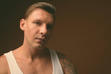 Siyah-beyaz siyah arka plan beyaz kolsuz bluz giyen kaslı adam stüdyo çekim