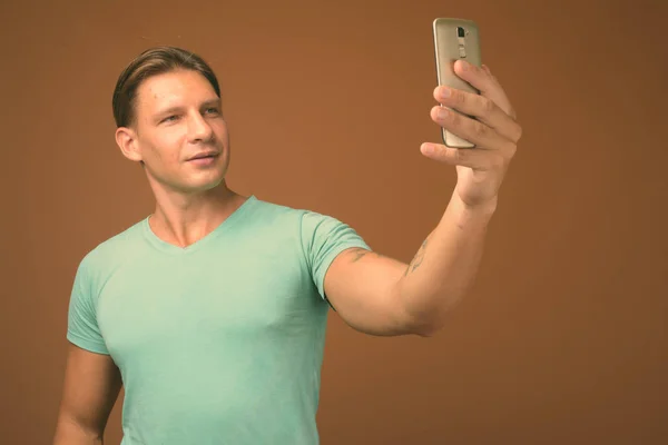 Студийный кадр мускулистого человека на коричневом фоне — стоковое фото