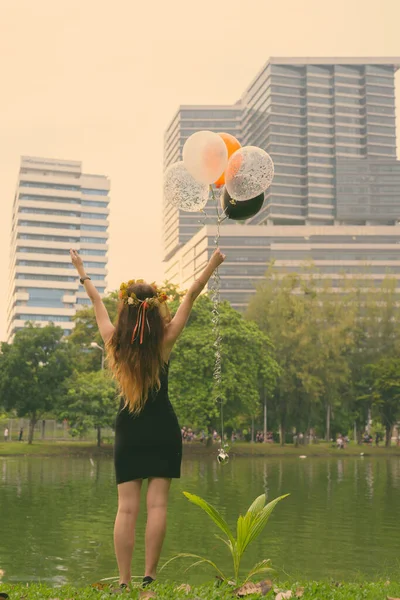 Joven hermosa mujer celebrando la graduación en el parque en Bangkok, Tailandia —  Fotos de Stock