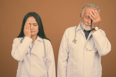 Komuta sizde doktor ve olgun Asyalı kadın doktor kahverengi zemin karşı birlikte stüdyo çekim