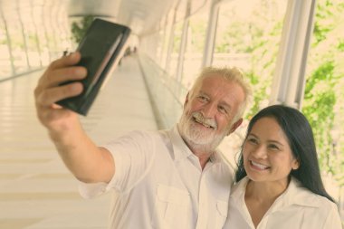 Olgun çok etnik gruptan oluşan çift birlikte yaya köprüsü Bangkok, Tayland, rahatlatıcı portresi