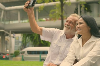 Olgun çok etnik gruptan oluşan çift Bangkok, Tayland için bina dışında rahatlatıcı portresi