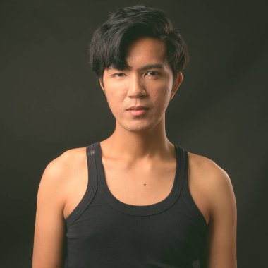 Genç yakışıklı Asya adam siyah arka plan stüdyo çekim