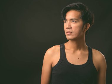 Genç yakışıklı Asya adam siyah arka plan stüdyo çekim