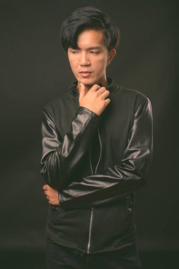 Genç yakışıklı Asya adam siyah arka plan stüdyo çekim