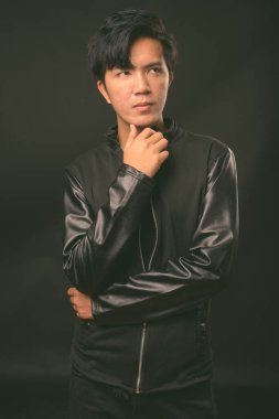 Genç yakışıklı Asya adam siyah arka plan stüdyo çekim