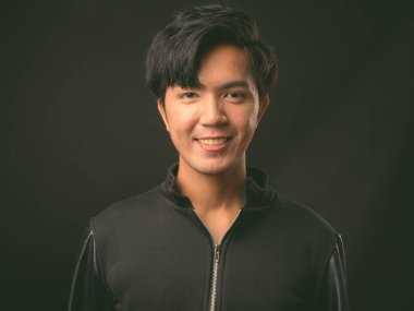 Genç yakışıklı Asya adam siyah arka plan stüdyo çekim