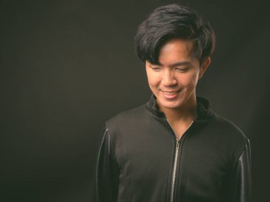 Genç yakışıklı Asya adam siyah arka plan stüdyo çekim