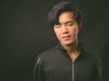 Genç yakışıklı Asya adam siyah arka plan stüdyo çekim